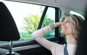 Senior transportation - businesswoman looking through car window